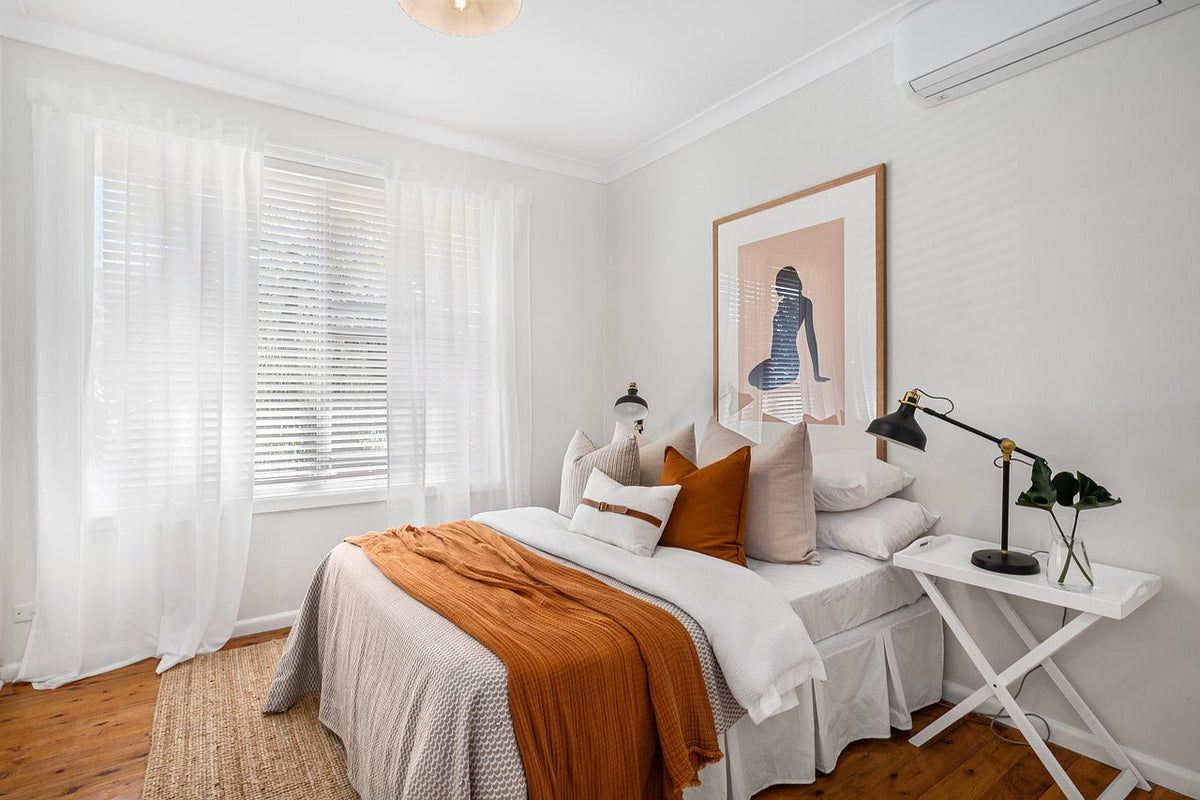 Bright, tidy bedroom with a neatly made bed and pillows