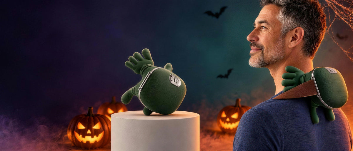 Man relaxing with the LeSomagic hand-shaped neck massager beside glowing Halloween pumpkins